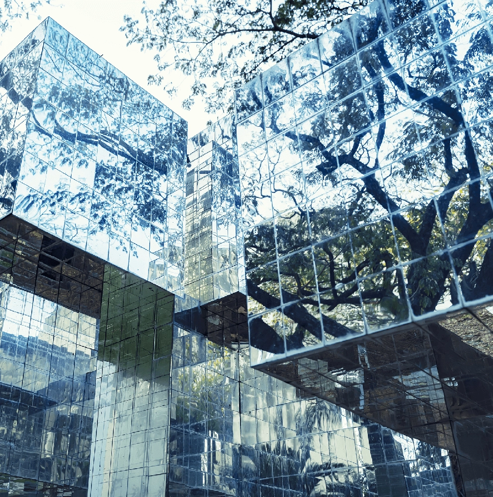Modern office building with reflective glass facade and trees